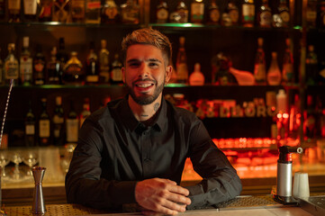 Young elegant barman working behind a bar counter mixing drinks