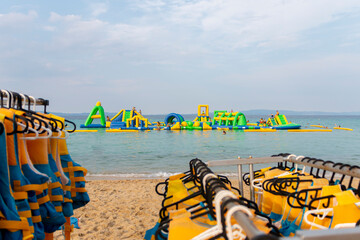 Ormos Panagias, Greece, July 31. 2022: Inflatable bouncing castle drifting on waves of Aegean Sea....