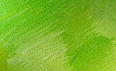 A close-up view of a canvas with vibrant green paint applied in thick, textured strokes, showcasing...