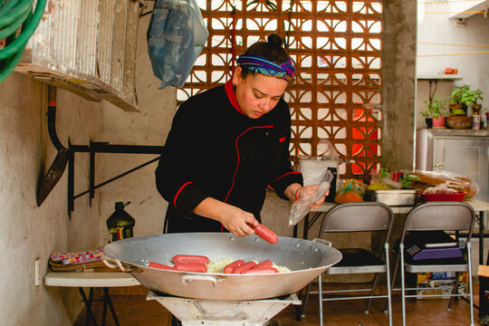 Latin woman preparing paella for her business