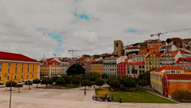 Aerial view of Lisbon downtown on a sunny day with epic cloudy sky. Flying back from Paco do Arco revealing the Tagus River 
