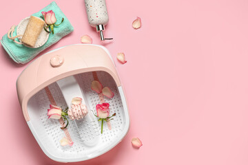 Composition with massage foot bath, spa supplies and rose flowers on pink background