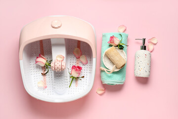 Composition with massage foot bath, spa supplies and rose flowers on pink background