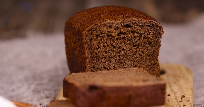 a loaf of rye black bread made from rye and wheat flour, a square dark loaf of bread on the table