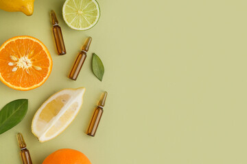 Ampules with vitamin C and fresh citrus fruits on color background