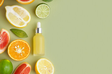 Composition with bottle of essential oil and fresh citrus fruits on color background