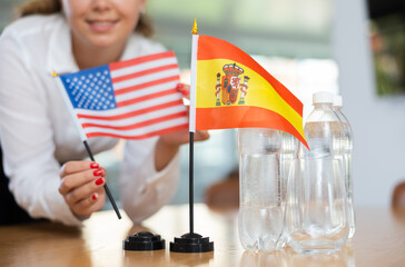 Little flag of Spain on table with bottles of water and flag of the USA put next to it by positive...