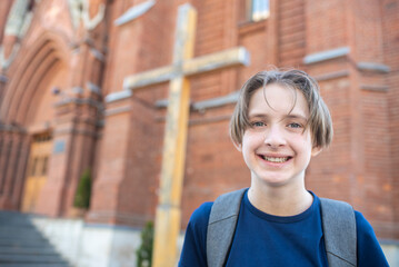 portrait of an 11 year old happy boy in front of a Catholic church