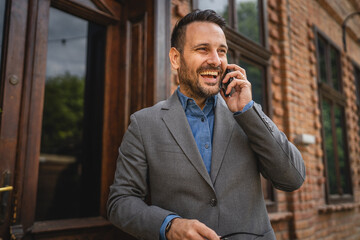 Portrait of adult man stand in a restaurant and talk on mobile phone