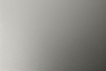 A tight shot of a polished metal surface adorned with a silver pattern, overlain by silver metallic foil
