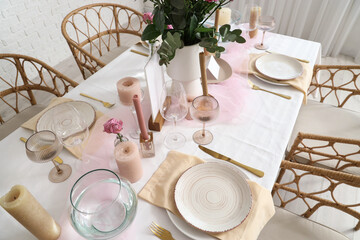Beautiful table setting with roses and candles for wedding celebration in room