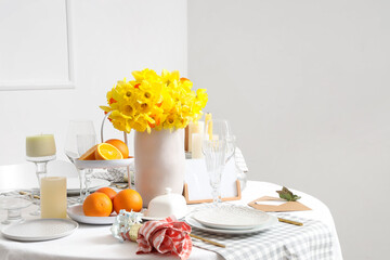 Beautiful table setting with yellow daffodils for wedding celebration in room