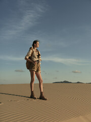 Lonely woman standing in the vast desert landscape, gazing into the unknown horizon