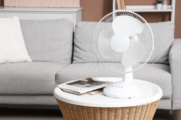 Modern electric fan on coffee table in living room