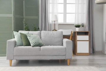 Interior of living room with green folding screen, sofa and table