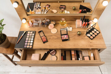 Makeup products on table in dressing room, top view