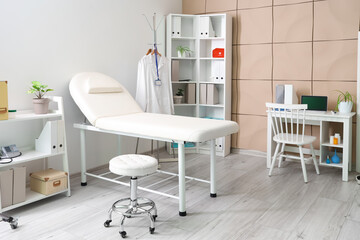 Interior of medical office with couch, shelf units and doctor's workplace