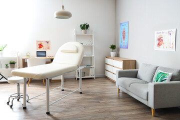 Interior of medical office with couch, sofa and doctor's workplace