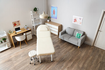 Interior of medical office with couch, sofa and doctor's workplace