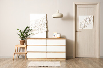 Interior of light room with painting on commode