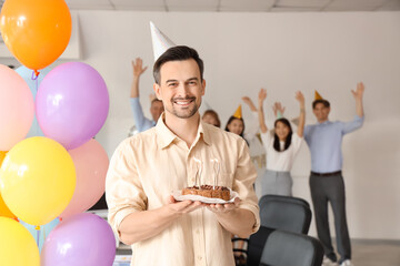Young businessman cake at birthday party in office