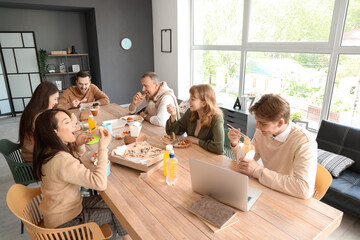Business colleagues having lunch at table in office kitchen