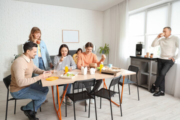 Business people having lunch at table in office kitchen