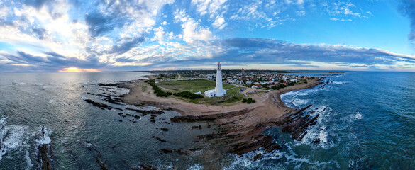 Costa con faro al atardecer en el mar La paloma, uruguay 