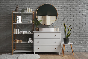 Interior of bathroom with shelf unit, sink and mirror