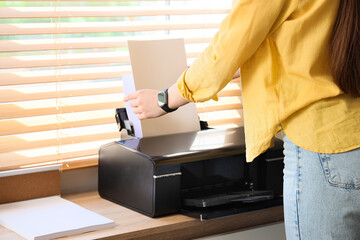 Businesswoman using printer in office, closeup