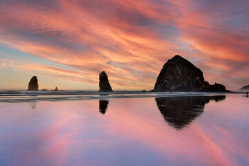 USA, Oregon. Cannon Beach and Haystack Rock at sunset and low tide