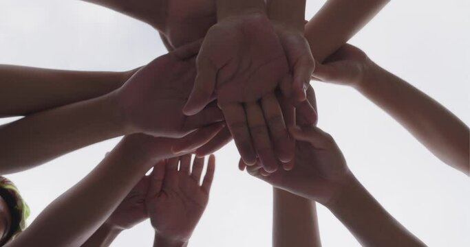 Successful team, many hands holding together on sky background
