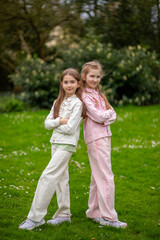 Two friendly girls in light-toned clothing with smiles enjoying