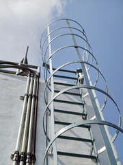 metal staircase on cement wall with blue sky