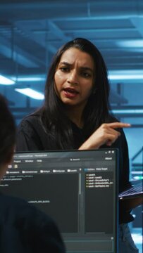 Vertical video Supervisor in server hub managing multiracial team of programmers looking for equipment misconfigurations. Manager coordinating tech specialists fixing data center damages