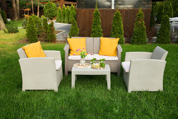 Easter decorations. Bouquet of tulips in vase, bunny figures and decorated eggs on table in backyard