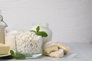 Different dairy products and mint on white table