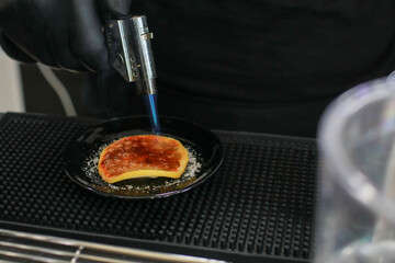 Torch burning on lemon become Caramelizing brown sugar. Preparation before serving decoration on drink or dessert.