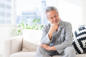 悩むシニア男性　パジャマ