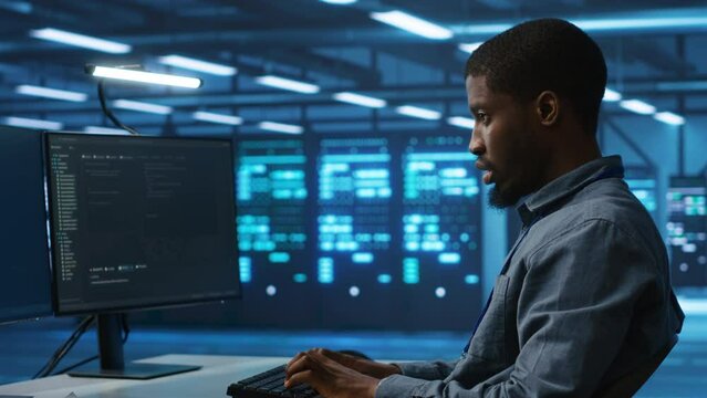 Software developer programming in high tech facility with server rows providing computing resources for different workloads. IT expert supervising data center supercomputers