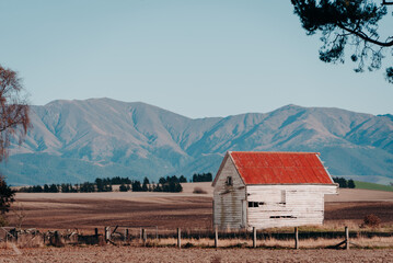 Old Barn in Field With Mountains in Background