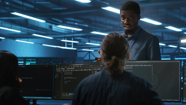 Supervisor in server hub workplace managing diverse team of developers looking for equipment software misconfigurations. Manager coordinating professionals mending data center bugs