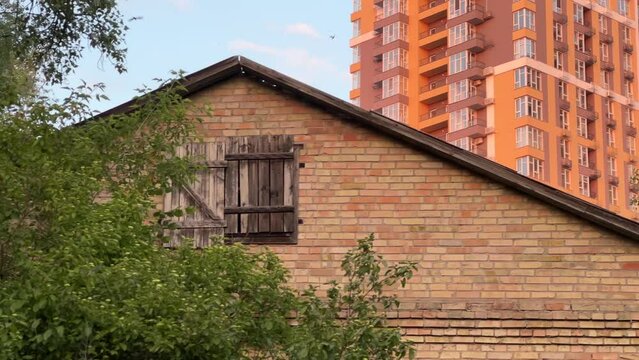 Urban Encroachment: The Vanishing Suburban Idyll as High-Rise Modernity Engulfs an Abandoned Single-Family Home. Long shot