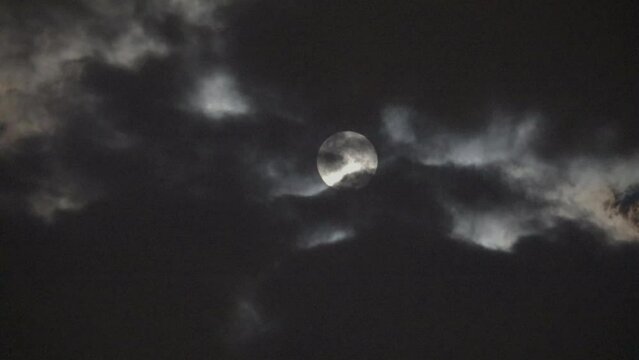 NORMAL SPEED VIDEO OF DRAMATIC NIGHT SKY WITH FULL MOON AMONG THE DARK CLOUDS