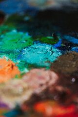 mix of colors paints and brushes in a pallet from an artist