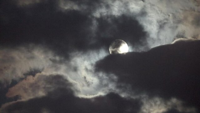 NORMAL SPEED VIDEO OF DRAMATIC NIGHT SKY WITH FULL MOON AMONG THE DARK CLOUDS