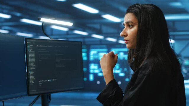 Meticulous engineer inspecting operational server rows in computer network security data center. Woman supervising supercomputers providing processing and memory resources for various workloads