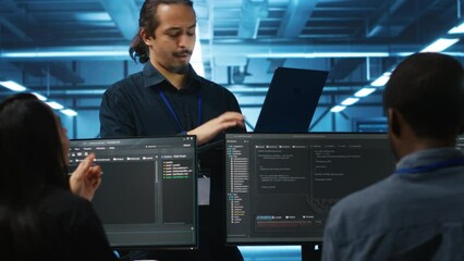 Manager and IT support specialists working together, supervising server rows in computer network security data center. Supervisor and multiethnic employees overseeing supercomputers