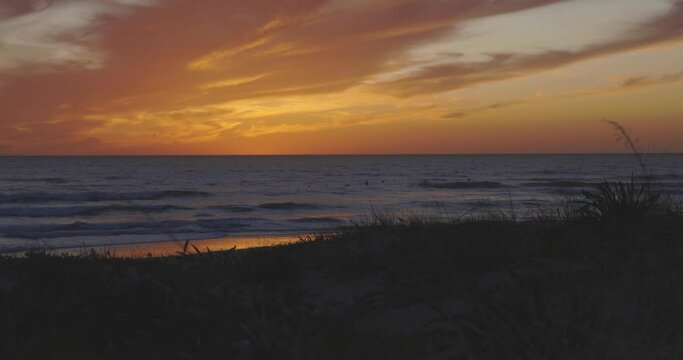  People silhouette swimming in ocean water at sunset with dramatic sky