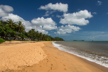 Experience the pristine beauty of Trinity Beach in Far North Queensland, Australia, where golden sands meet azure waters under a tropical sun, inviting relaxation and coastal bliss.